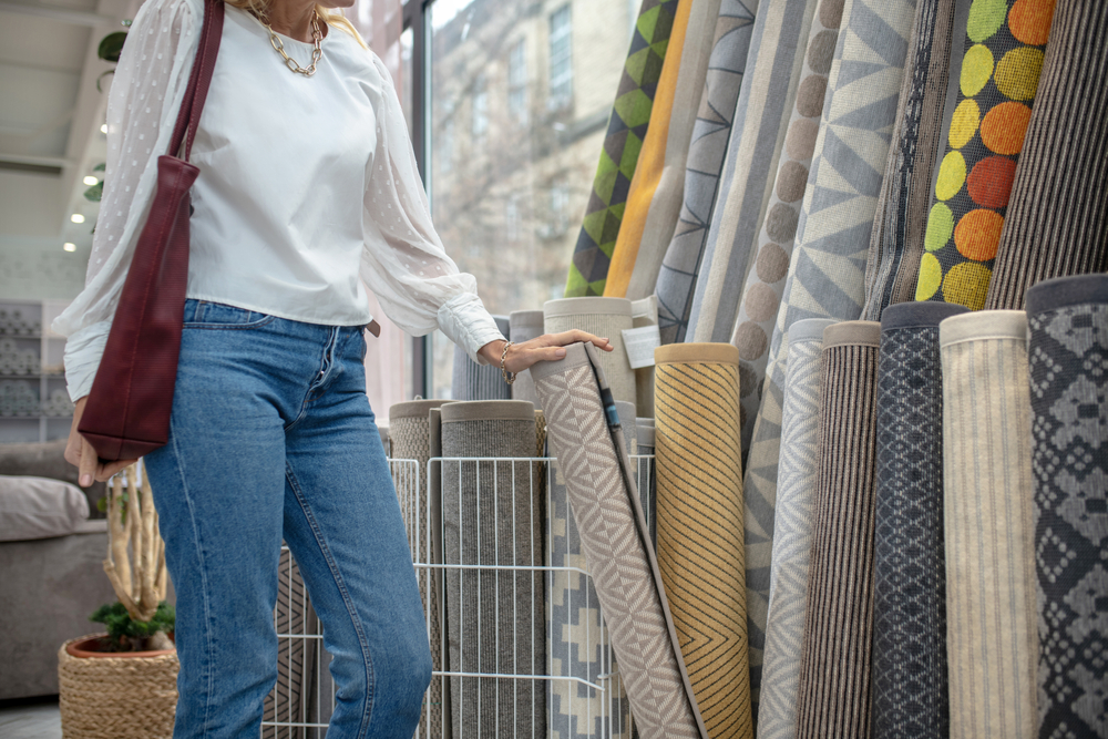 Carpets,Assortment.,Woman,In,A,White,Blouse,And,Jeans,Standing