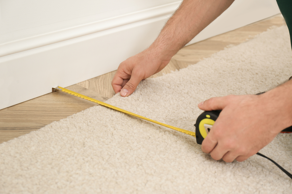 Worker,With,Measuring,Tape,Installing,New,Carpet,Indoors,,Closeup